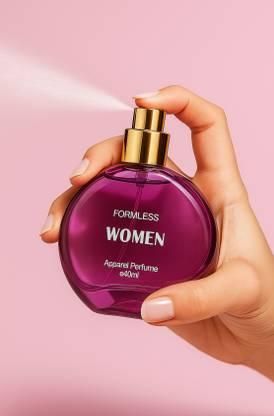 Hand holding a purple perfume bottle labeled 'Formless Women' against a pink background